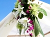 White lilies and purple orchids on bamboo arch, beach wedding