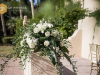 Close Up of Back of Aisle Floral Arrangement in White Flowers and Tropical Leaves
