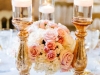 Beautiful Guest Table Centerpiece featuring a low arrangement in gold footed bowl with 3 gold pillar candle holders with floating candles